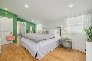 A bedroom with a bed, bedside tables, a mirror, and a window with sheer curtains. - Walk Downtown & Waterfront | Dunedin's Best Street (Dunedin)