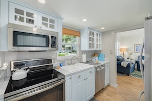 A modern kitchen with a built-in microwave, oven, and dishwasher. - Walk Downtown & Waterfront | Dunedin's Best Street (Dunedin)