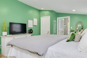 A bedroom with a bed, a television, a dresser, and a door leading to another room. - Prized Dunedin St | Walk Downtown & Waterfront (Dunedin)