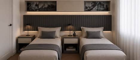 Habitación de hotel con dos camas, mesitas de noche, un estante en la pared con una obra de arte y una puerta.