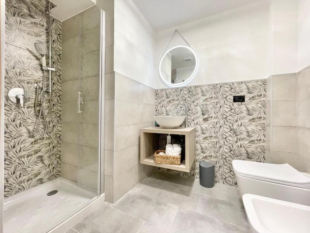 Une salle de bain moderne équipée d’une douche, de toilettes et d’un lavabo.
