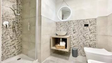 Une salle de bain moderne équipée d’une douche, de toilettes et d’un lavabo.