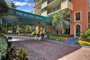 The Mutiny Hotel entrance with a covered walkway, palm trees, and a brick pathway. - Modern Bay View Balcony in the Grove Free Parking (Miami)