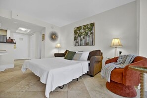 A hotel room with a bed, a sofa, a chair, a painting, and a lamp. - Modern Bay View Balcony in the Grove Free Parking (Miami)