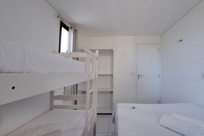 Una habitación con literas, un armario y una puerta.