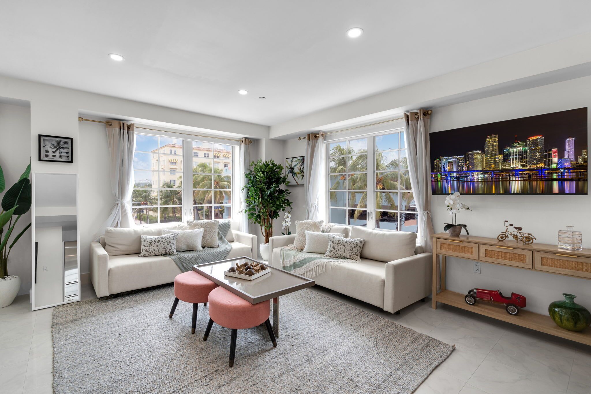 A modern living room with a sofa set, a coffee table, and a cityscape view.
