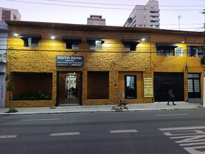 Un hotel-hostal amb façana de pedra, diverses finestres i un rètul.