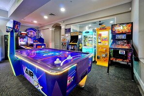 Ein Raum mit einem Tischfußballtisch, Pac-Man-Spielautomaten und einem Krabschere-Automaten.