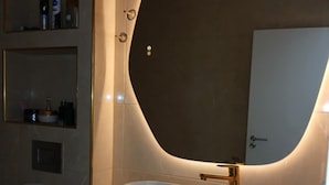 A bathroom with a modern sink, a large mirror, and a toilet.