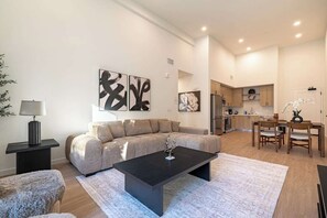 A modern living room with a sofa, coffee table, and artwork on the walls.