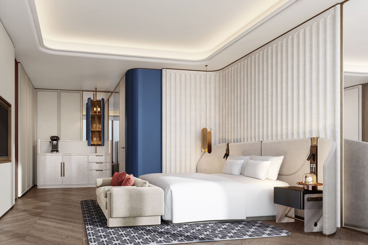Une chambre d’hôtel moderne dotée d’un grand lit, d’un coin salon et d’une kitchenette.