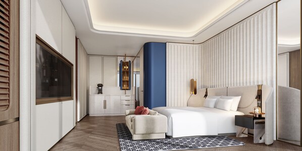 Una habitación de hotel moderna con una cama grande, zona de estar y kitchenette.