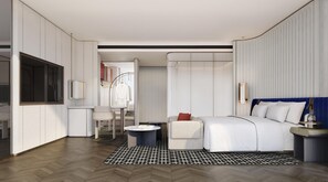Una camera d'albergo moderna con un letto, un comodino e un'area salotto con una sedia e un tavolo.