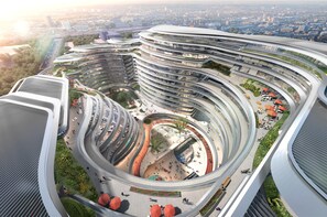 Een meerlaags gebouw met een gebogen vorm en een centraal atrium, omringd door groen en terrassen.