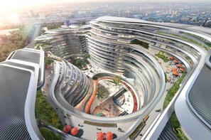 Un edificio a più livelli, di forma circolare, con una piazza centrale e terrazze circostanti.
