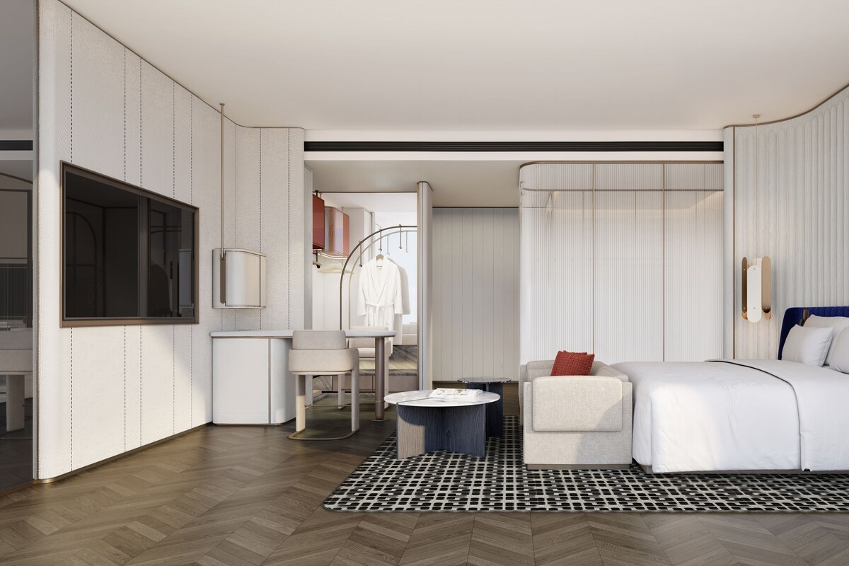Une chambre d’hôtel moderne équipée d’un lit, d’une table de chevet et d’un coin salon.