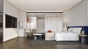Une chambre d’hôtel moderne équipée d’un lit, d’une table de chevet et d’un coin salon.
