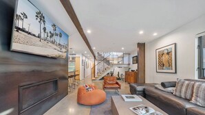 A modern living room with a leather sofa, a bean bag, and a coffee table with magazines. - High Tide | Modern Design, Venice Energy (Los Angeles)