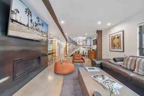 A modern living room with a leather sofa, a bean bag, and a coffee table with magazines. - High Tide | Modern Design, Venice Energy (Los Angeles)