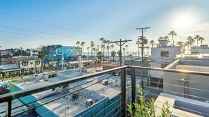 A rooftop view with a clear sky, power lines, and palm trees. - High Tide | Modern Design, Venice Energy (Los Angeles)