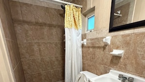 Ein Badezimmer mit Toilette, Waschbecken und Duschbereich.