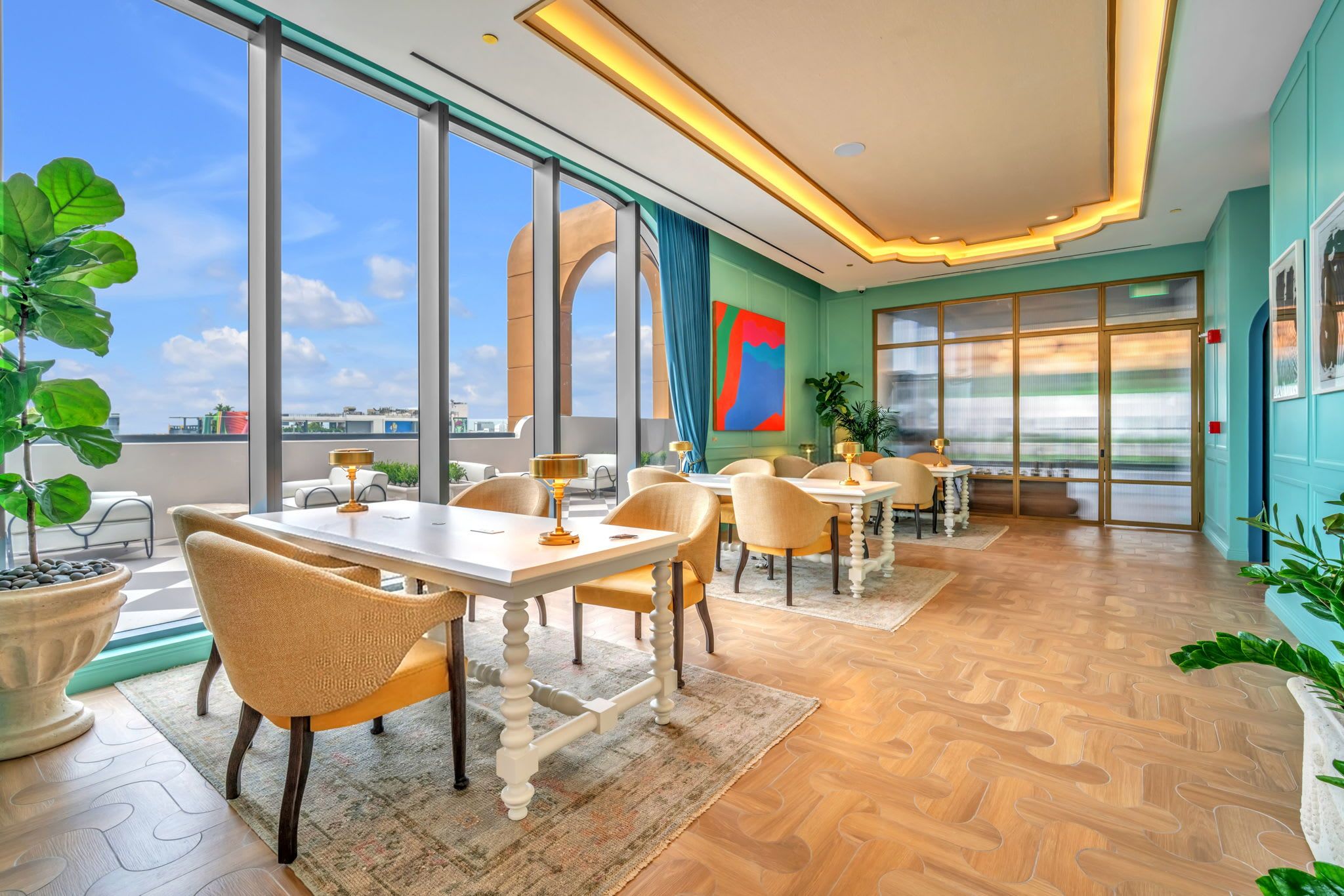 Un vaste espace dédié à la salle à manger, doté de grandes fenêtres, offrant une vue sur le paysage urbain, et présentant un aménagement intérieur moderne.