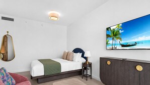 Ein Hotelzimmer mit Bett, Fernseher, Schreibtisch und einer Couch.