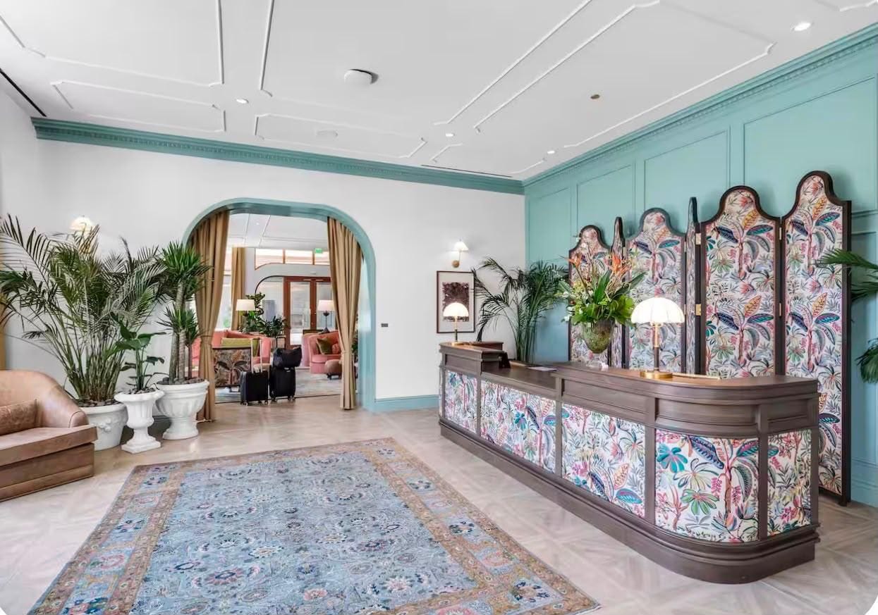 A reception area with a patterned rug, a reception desk, and a decorative wall panel.