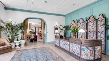 A reception area with a patterned rug, a reception desk, and a decorative wall panel.
