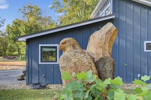 Ein Gebäude mit einer großen Holzskulptur eines Adlers, einem Fenster und einer Steinmauer.