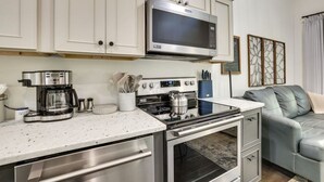 Una cocina moderna con electrodomésticos de acero inoxidable, una cafetera y un hervidor.
