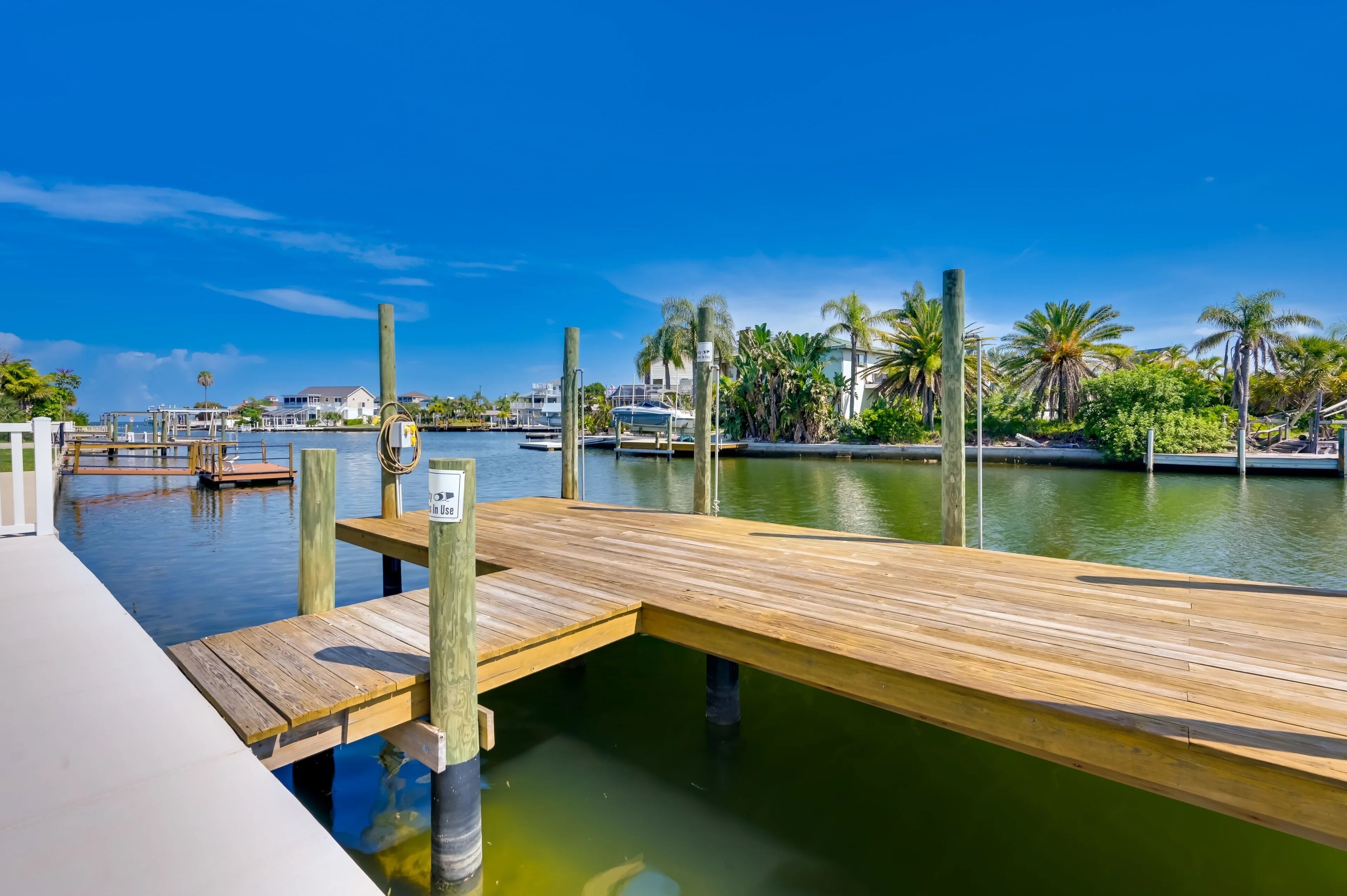 A wooden dock extending into a calm body of water with a clear sky above.