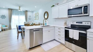 A modern kitchen with white cabinetry, a dishwasher, a microwave, and an oven. - Waterfront 3-bedroom, 3-bath vacation rental in Hudson (Hudson)