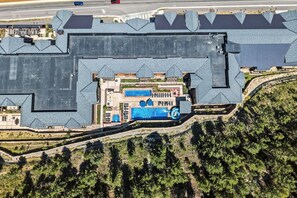 A large building with multiple roofs, a swimming pool, and a parking area. - Frontgate | Luxury Condo W/Resort Amenities (Avon)