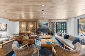 A modern interior with a fireplace, comfortable seating, and a large window offering a scenic view. - Frontgate | Luxury Condo W/Resort Amenities (Avon)