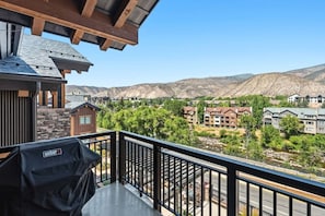 A balcony with a grill, overlooking a residential area with houses and mountains. - Frontgate | Luxury Condo W/Resort Amenities (Avon)