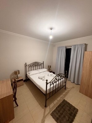 A bedroom with a bed, bedside tables, a desk, and a chair. - Spacious 3-bedroom apartment in wonderful St. Paul's Bay with AC (St. Paul's Bay)