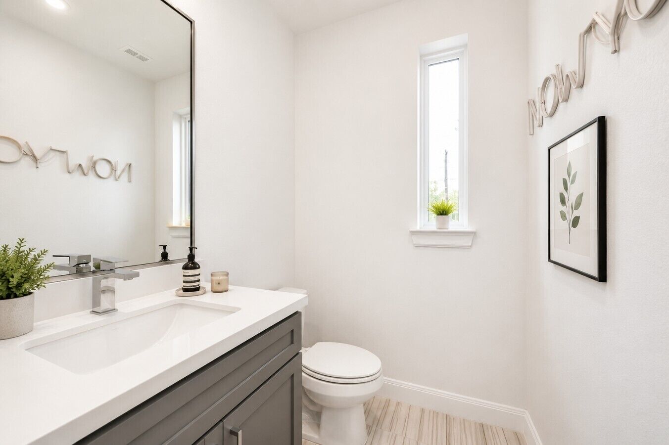 Un baño moderno con un lavabo blanco, un inodoro y una ventana.