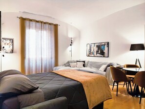 A hotel room with a bed, a sofa, a dining table with chairs, a lamp, and artwork on the walls. - Vatican Best Suite: 3-Bathroom Suite | Early Check-in | Free Luggage (Roma)
