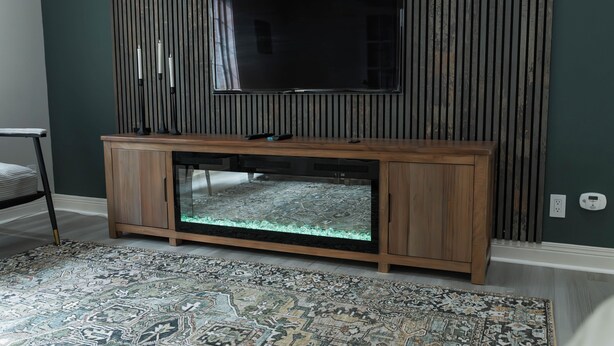 Um quarto com um armário de madeira, um aquário e uma televisão na parede.