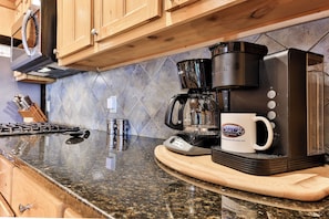 A kitchen with a coffee maker, a mug, and a knife block. - Painted Sky Lodge| Blue Ridge, GA (Morganton)