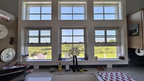 A kitchen with multiple windows, a sink, and various kitchen items on the counter. - 4 BR/2 BA Charmer! Sunset and Ocean Views, Steps to the Beach! (New Shoreham)