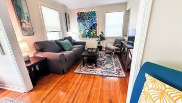 A living room with a sofa, coffee table, and a rug.