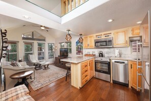 A modern kitchen with wooden cabinets, stainless steel appliances, and a large island.