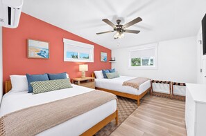 Une chambre d’hôtel avec deux lits, un ventilateur de plafond et une fenêtre donnant sur un beau paysage.
