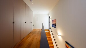 A hallway with wooden flooring, white walls, and a staircase with a handrail. - Stunning home in Duba (Duba)
