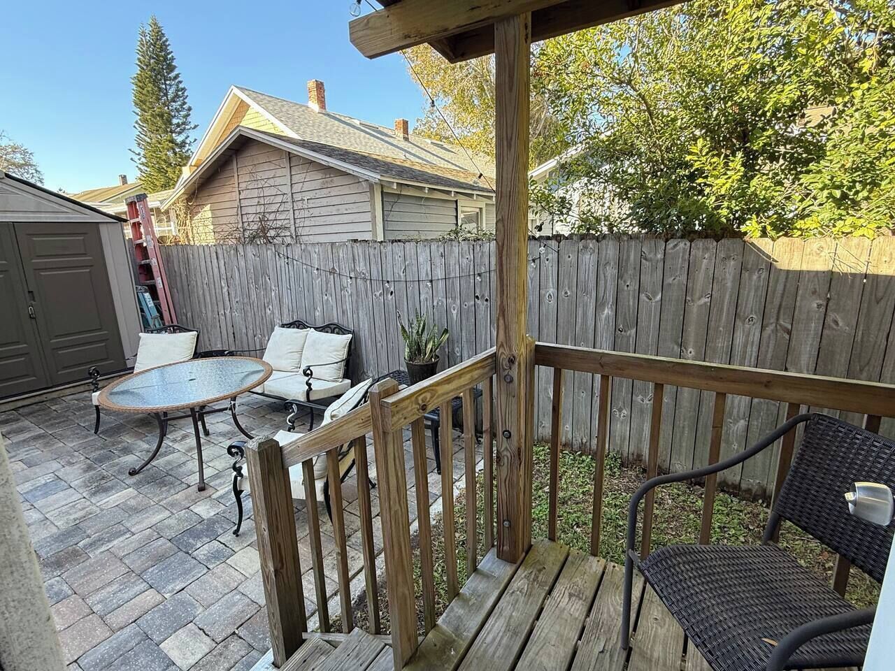 Una terraza de madera con mobiliario exterior, incluyendo una mesa y sillas.