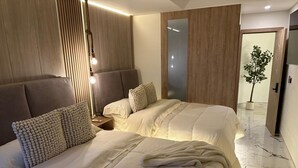 A hotel room with two beds, a wooden headboard, a nightstand, a mirror, and a potted plant. - Exclusive penthouse rooftop pool, luxury living and beach (Cartagena de Indias)