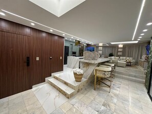 Ein modernes Interieur mit einer Marmortreppe, einer Sitzecke und einer Küche.