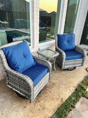 Wicker furniture with blue cushions, a glass table, and a view through glass doors. - Huge 4 bdrm house in Fate with theater room, Pool table, & private pool/jacuzzi. (Rockwall)